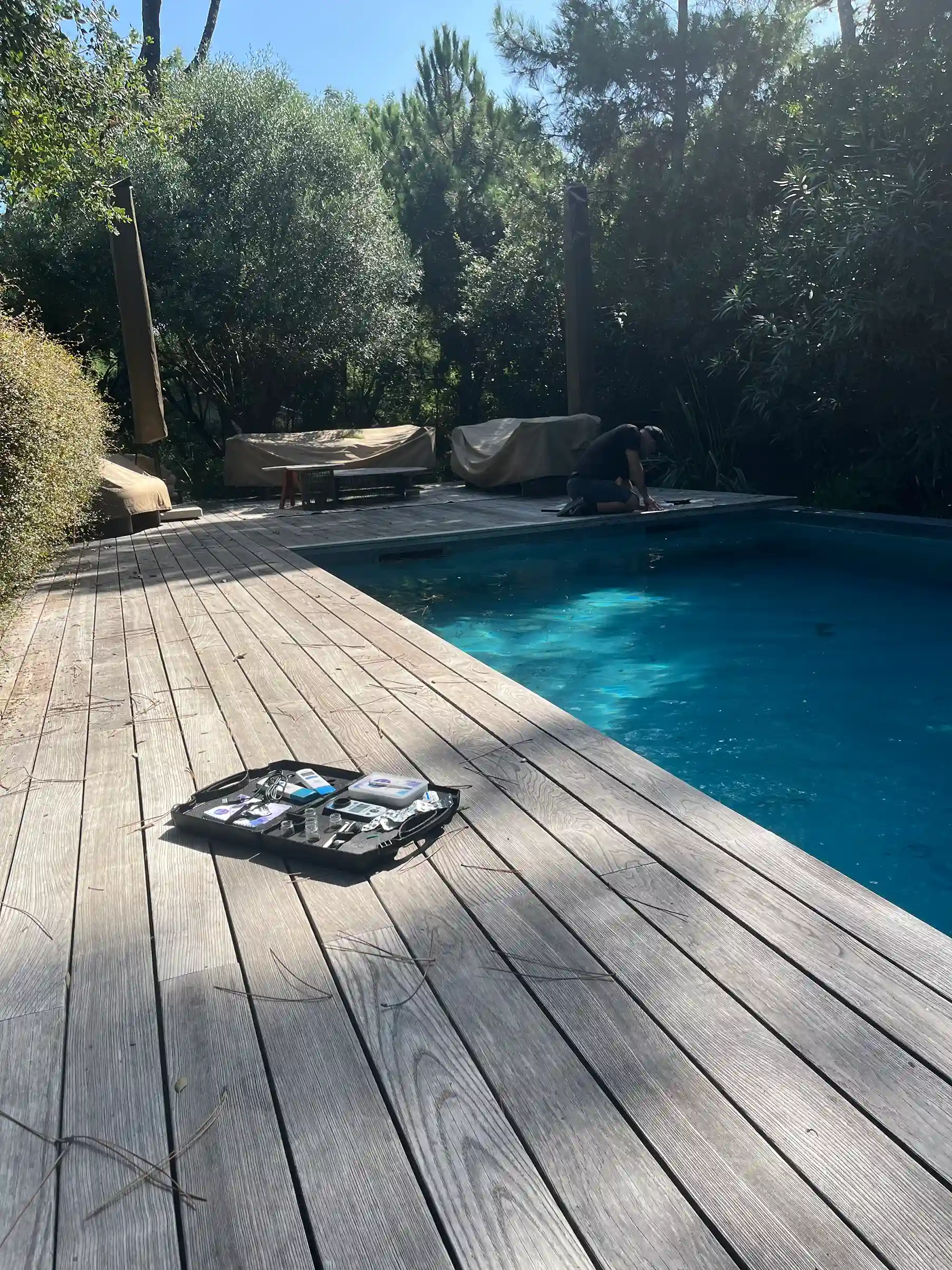 Technicien contrôlant l'eau d'une piscine en période de fortes chaleurs